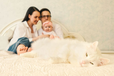 Full length of mother and baby on bed at home