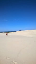 Scenic view of desert against clear blue sky