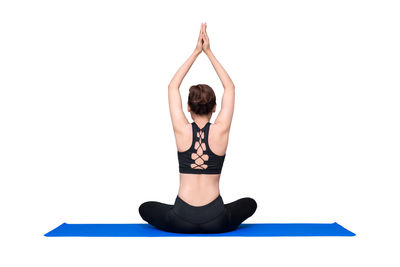 Midsection of woman with arms raised against white background