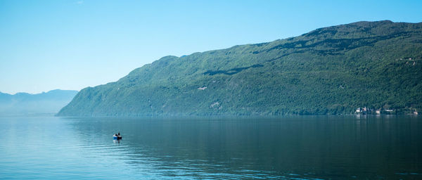 Boats in sea with mountains in background