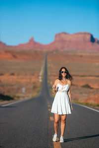 Young woman standing on road