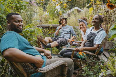 Cheerful male and female volunteers sitting in urban garden