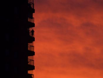 Low angle view of silhouette building against dramatic sky