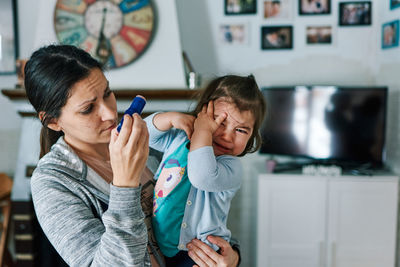 Brunette woman with child crying in her arms