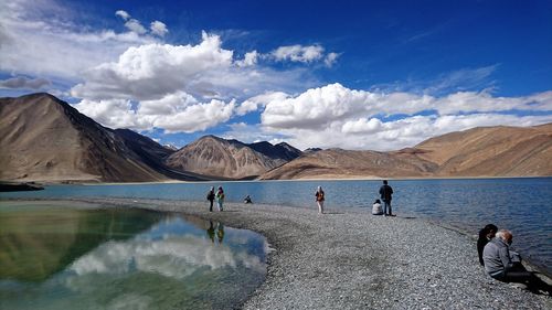 People on the path against lake and mountains