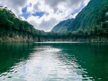 Scenic view of lake by mountains against sky