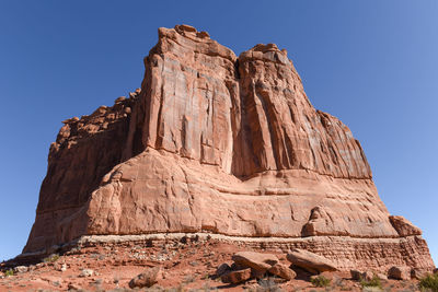 Low angle view of rock formation against clear blue sky