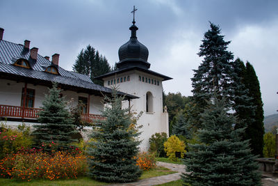 Low angle view of trees and building against sky