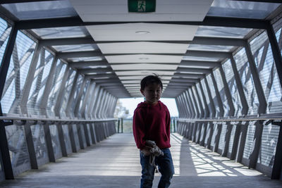 Boy standing in covered walkway