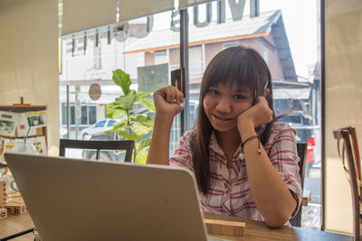 Portrait of woman using mobile phone in restaurant