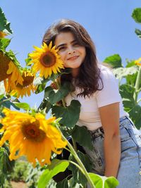 Portrait of woman with sunflower against sky