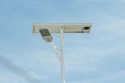 Low angle view of street light with solar panel against sky