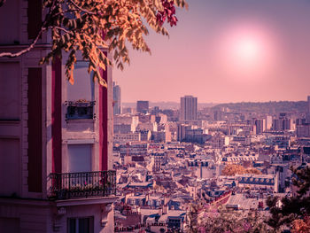 Buildings in city against sky during sunset