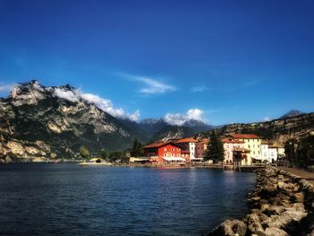 Scenic view of sea by buildings against blue sky