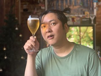Portrait of young man drinking glass
