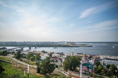 High angle view of cityscape by sea against sky