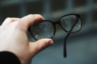 Cropped image of hand holding eyeglasses