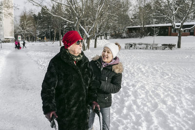 Senior woman with female home caregiver walking at winter