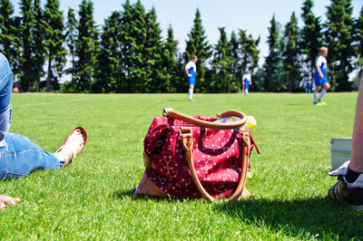 Low section of woman by soccer players on field