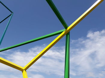 Low angle view of metallic rods against blue sky