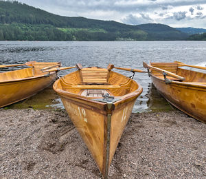 Boats moored in lake against sky