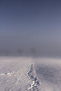 Scenic view of snow covered field against sky