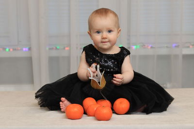 Portrait of cute baby girl sitting at home