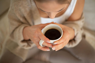 Midsection of woman holding coffee cup