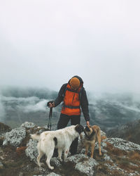 Man with dogs on top of the mountain