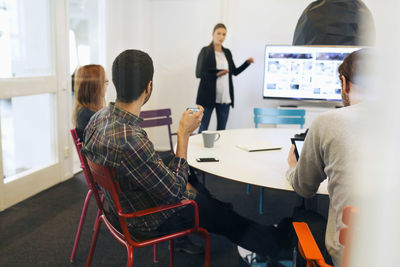 Businesswoman explaining during conference call in board room of creative office