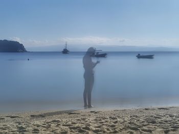 Man standing on beach against sky