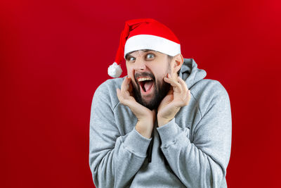 Portrait of man wearing hat against red background