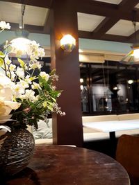 Illuminated flower vase on table in restaurant