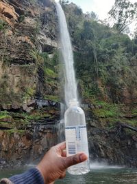 Cropped image of hand holding waterfall