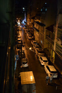 High angle view of illuminated street amidst buildings at night