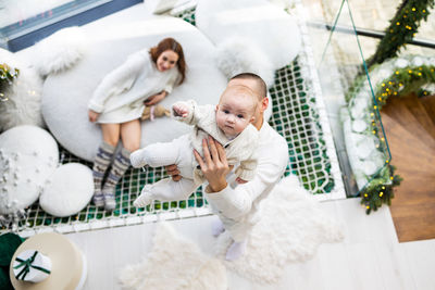 High angle view of cute girl playing with teddy bear on table