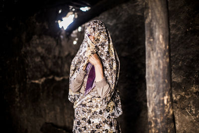 Woman with obscure face wearing sari while standing at home