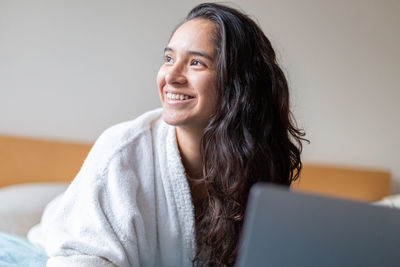 Portrait of young woman using laptop at home