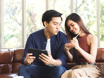 Young couple sitting on mobile phone