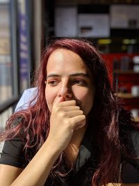 Thoughtful young woman looking away in cafe