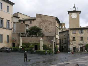 Man walking on street amidst buildings in city