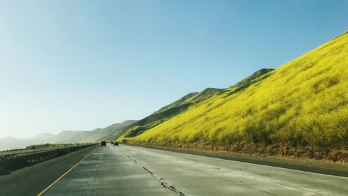 Road by mountain against clear sky