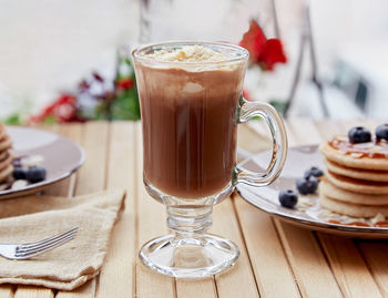 Sweet belgian chocolate with ice cream in glass and traditional pancakes with syrup and blueberry 