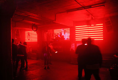 Rear view of people walking in illuminated building