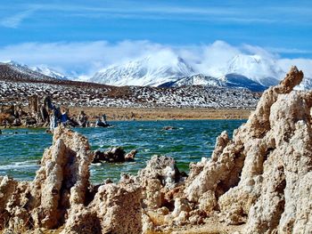 Scenic view of sea by rock formation against sky