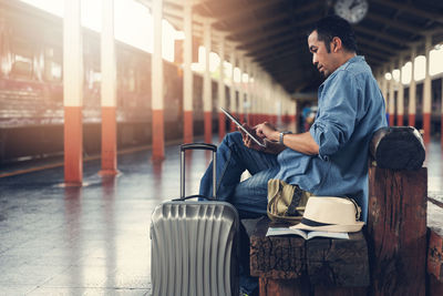 Man using mobile phone while sitting on seat