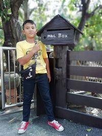 Portrait of teenage boy standing by sign