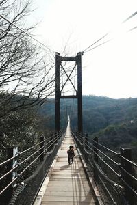 Woman walking on footbridge