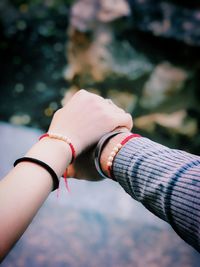 Cropped image of couple holding hands outdoors