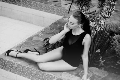 Full length of beautiful woman in swimwear reclining at poolside